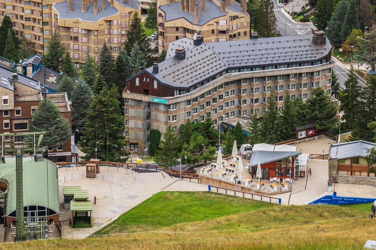 Un gran edificio con un parque enfrente. en Tuc Blanc, en Baqueira Beret