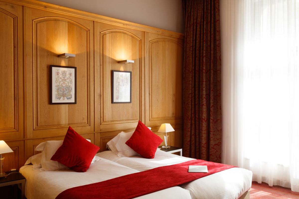 une chambre d'hôtel avec un lit aux oreillers rouges dans l'établissement Hôtel de Bourgtheroulde, Autograph Collection, à Rouen