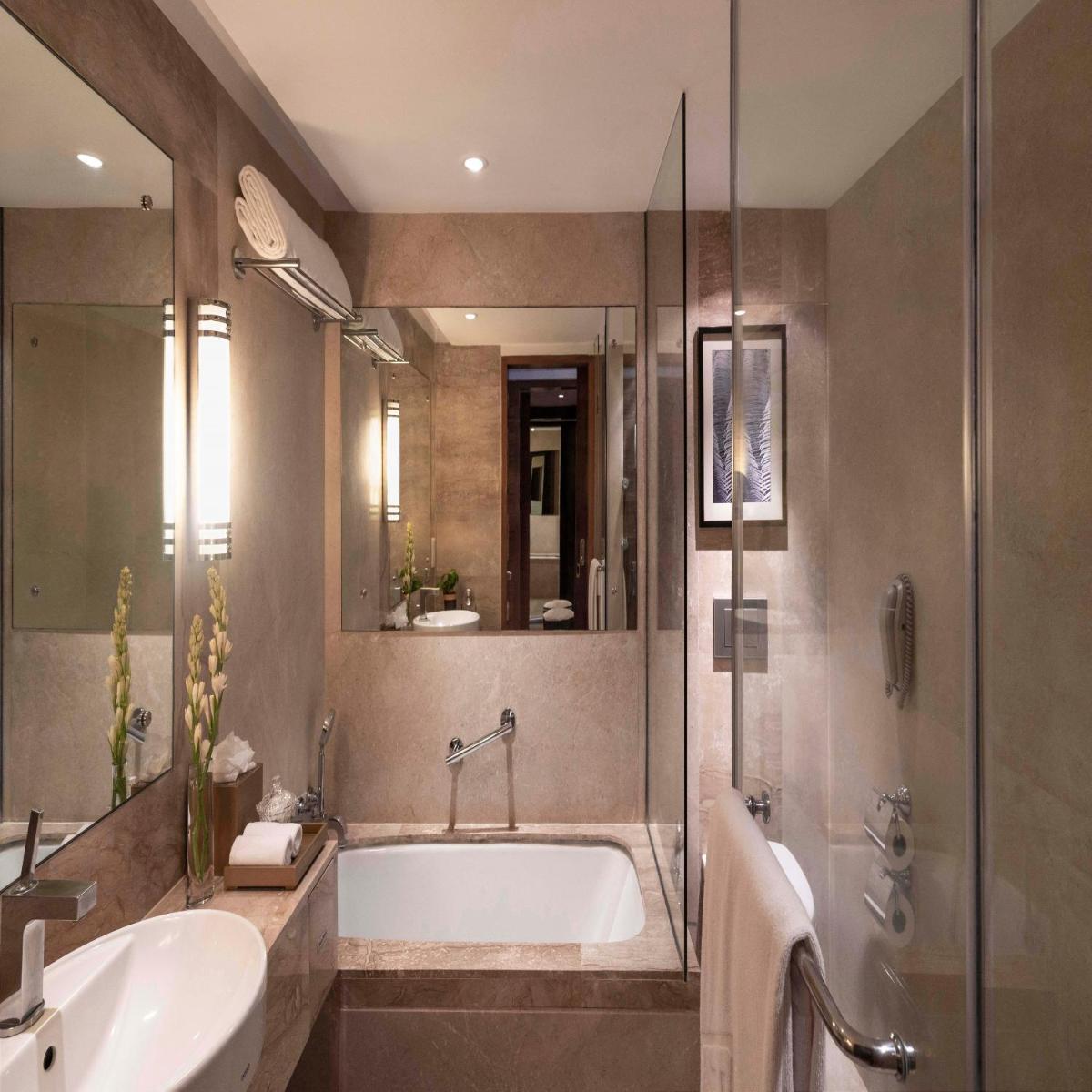 a bathroom with a tub and a sink and a shower at Taj Coromandel in Chennai
