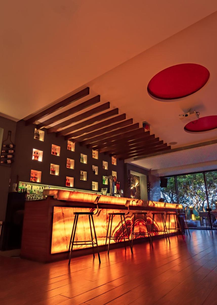 a bar with tables and chairs in a room at Hyatt Pune in Pune