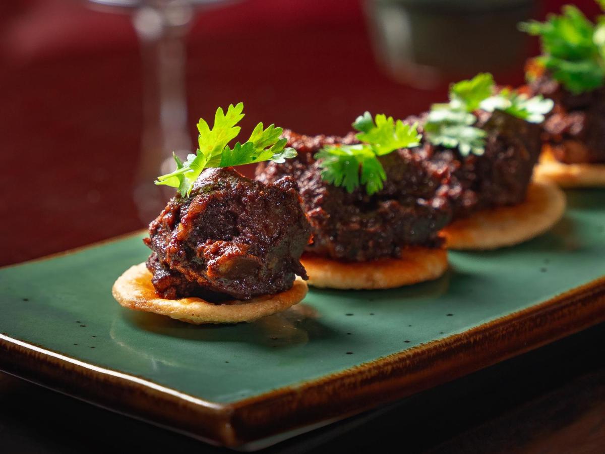two meat dishes on a green plate with parsley on top at Hyatt Pune in Pune