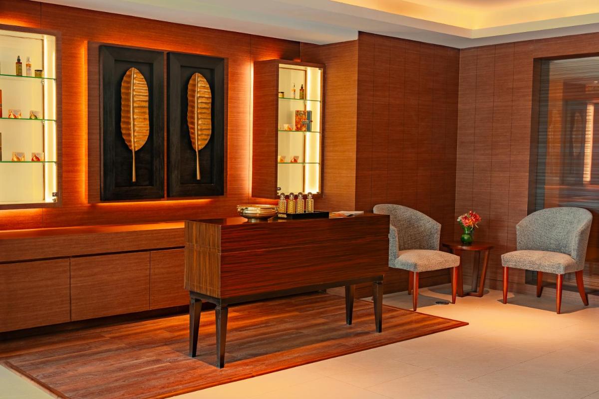 a living room with a wooden table and two chairs at Hyatt Pune in Pune