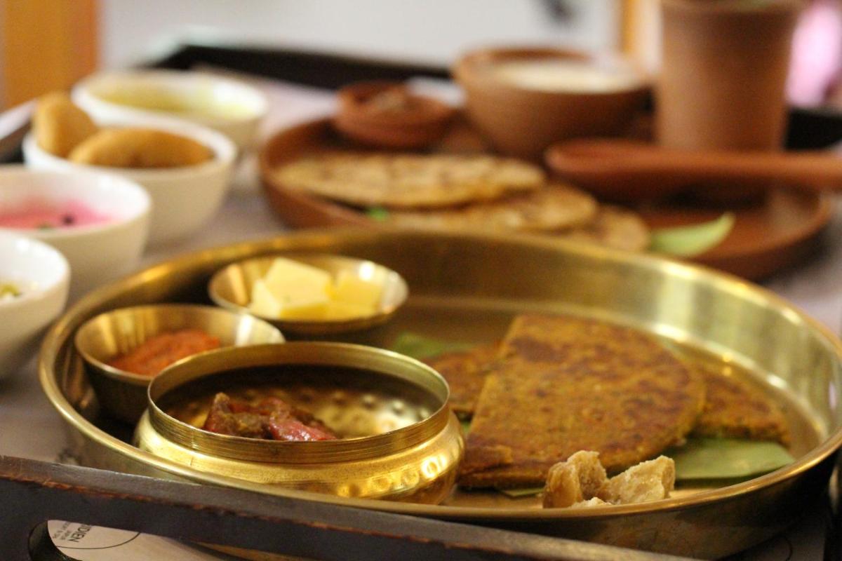 a metal tray filled with food on a table at Le Meridien Jaipur Resort & Spa in Jaipur +46 photos