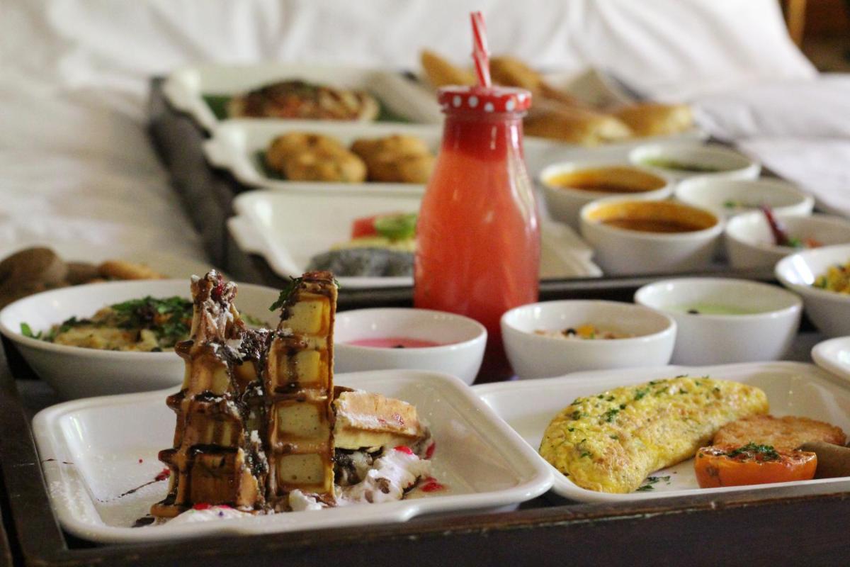 a tray filled with plates of food on a table at Le Meridien Jaipur Resort & Spa in Jaipur