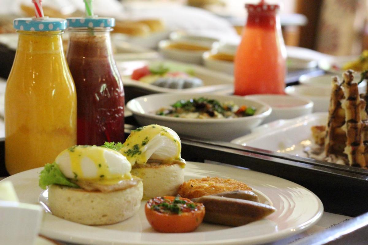 a table topped with plates of food and drinks at Le Meridien Jaipur Resort & Spa in Jaipur