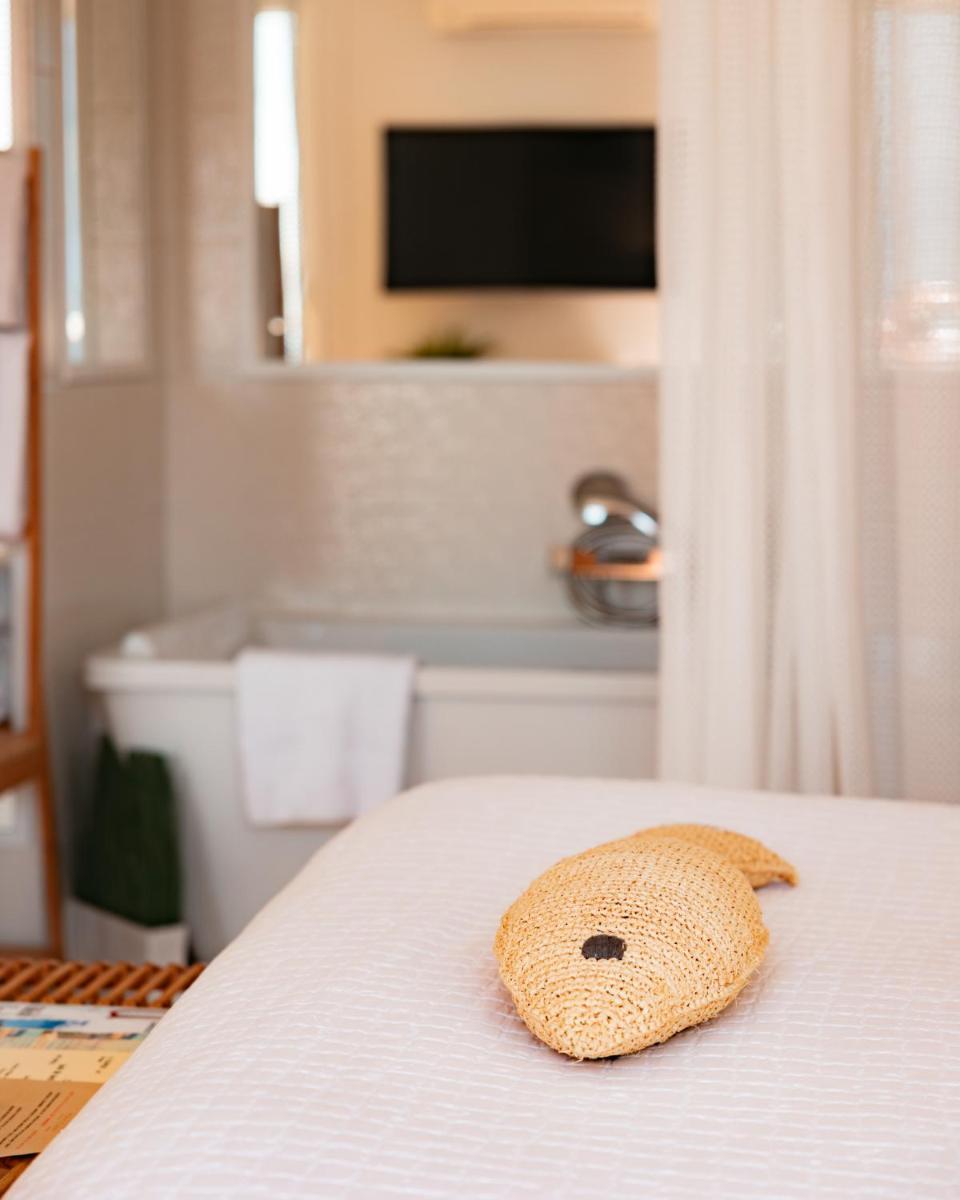 un animal farci est assis au-dessus d'un lit dans l'établissement Hotel de La Plage - Mahogany, à Cassis