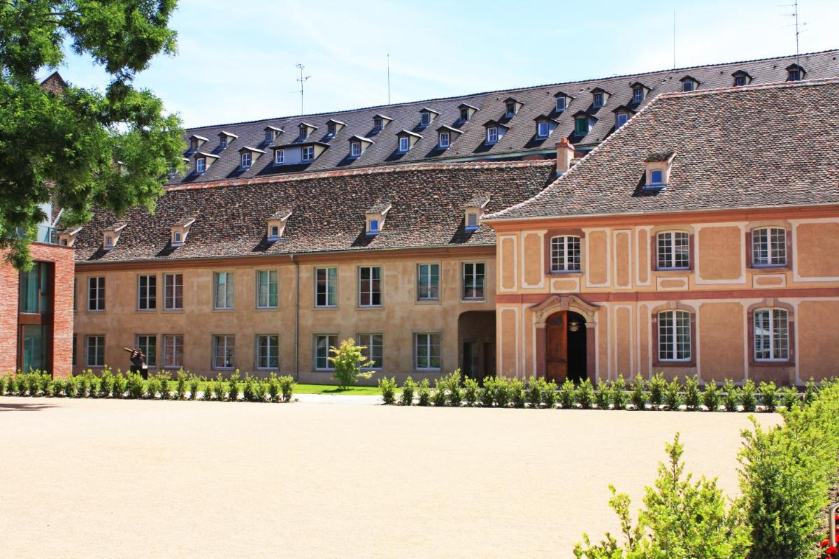 - une vue sur l'extérieur d'un grand bâtiment en briques dans l'établissement Hotel Les Haras, à Strasbourg