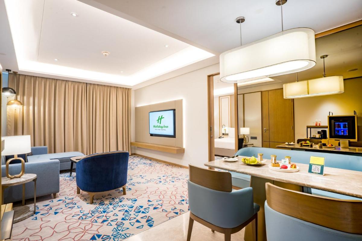 a hotel room with a dining area and a living room at Holiday Inn Lucknow Airport by IHG in Lucknow