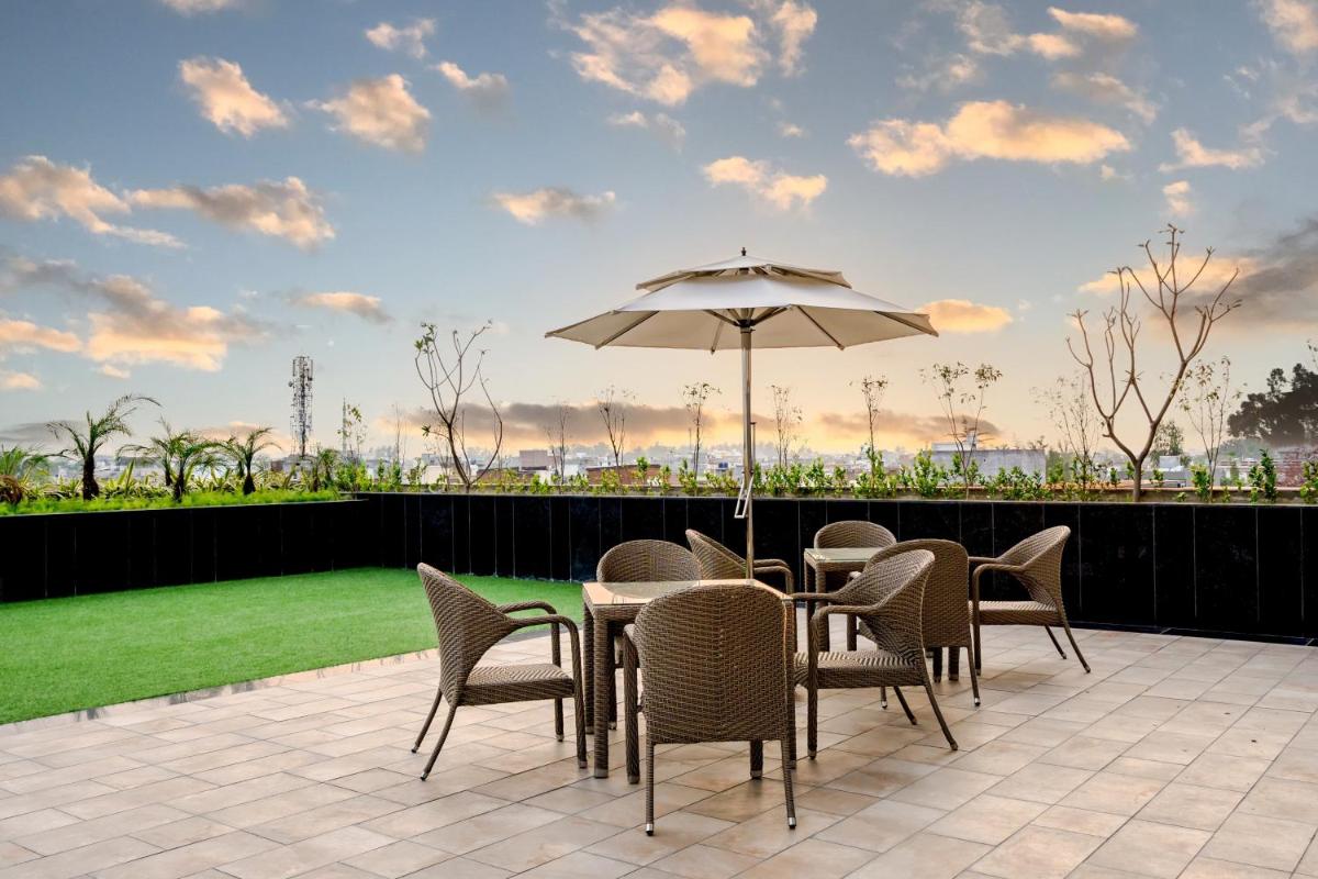 a patio with a table and chairs and an umbrella at Holiday Inn Lucknow Airport by IHG in Lucknow