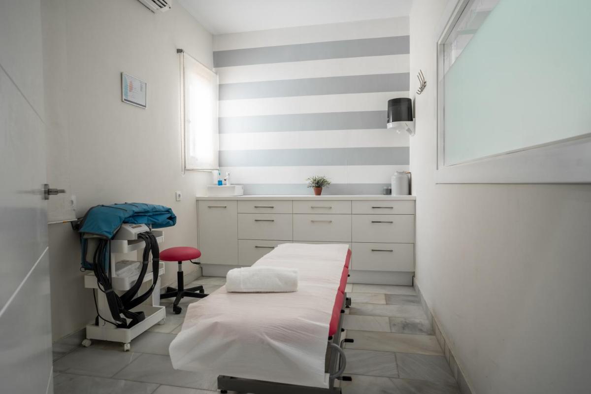 una habitación de hospital con una cama y una silla en Hotel Balneario de Chiclana, en Chiclana de la Frontera