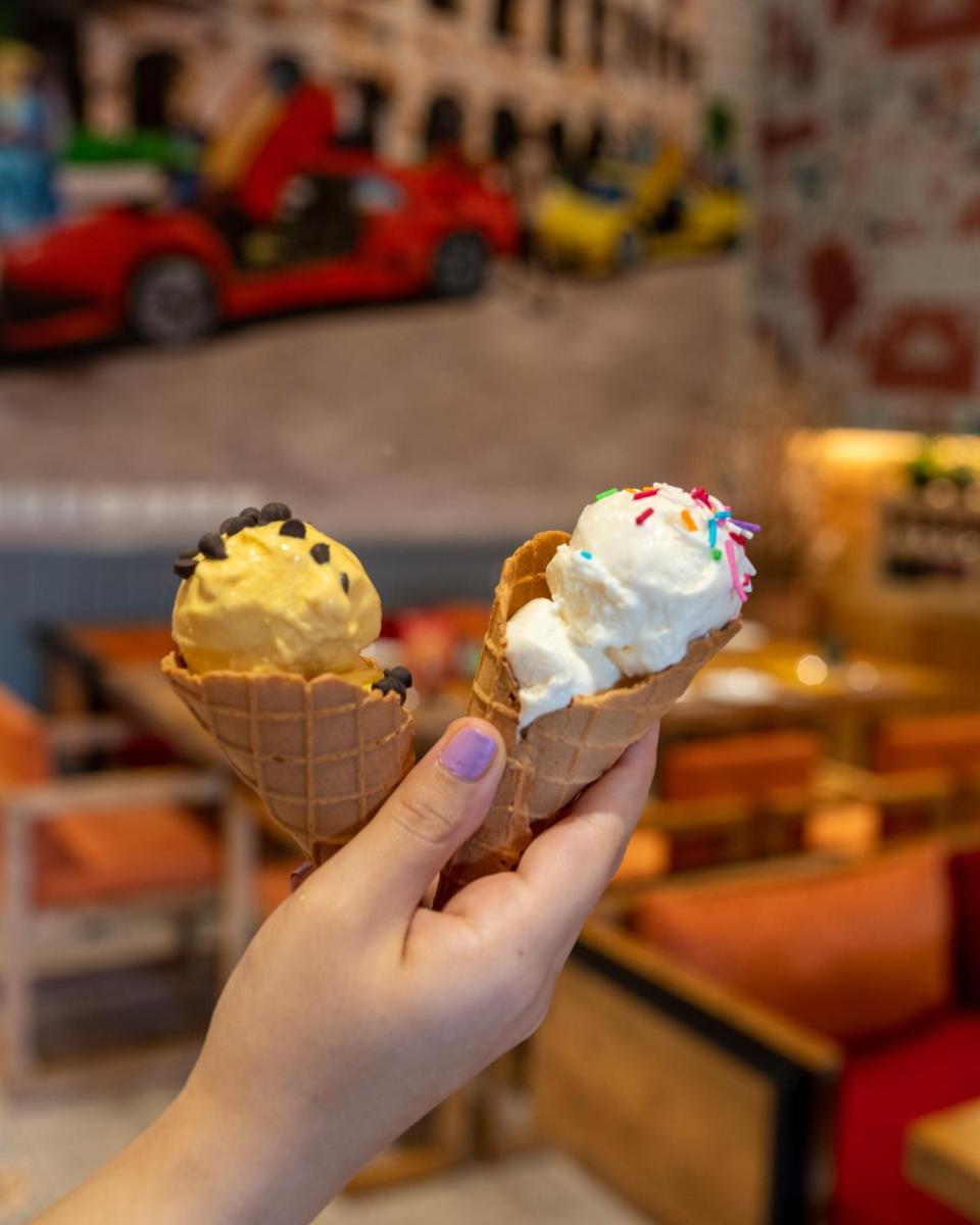 a person holding up two cones of ice cream at Holiday Inn New Delhi Aerocity by IHG in New Delhi