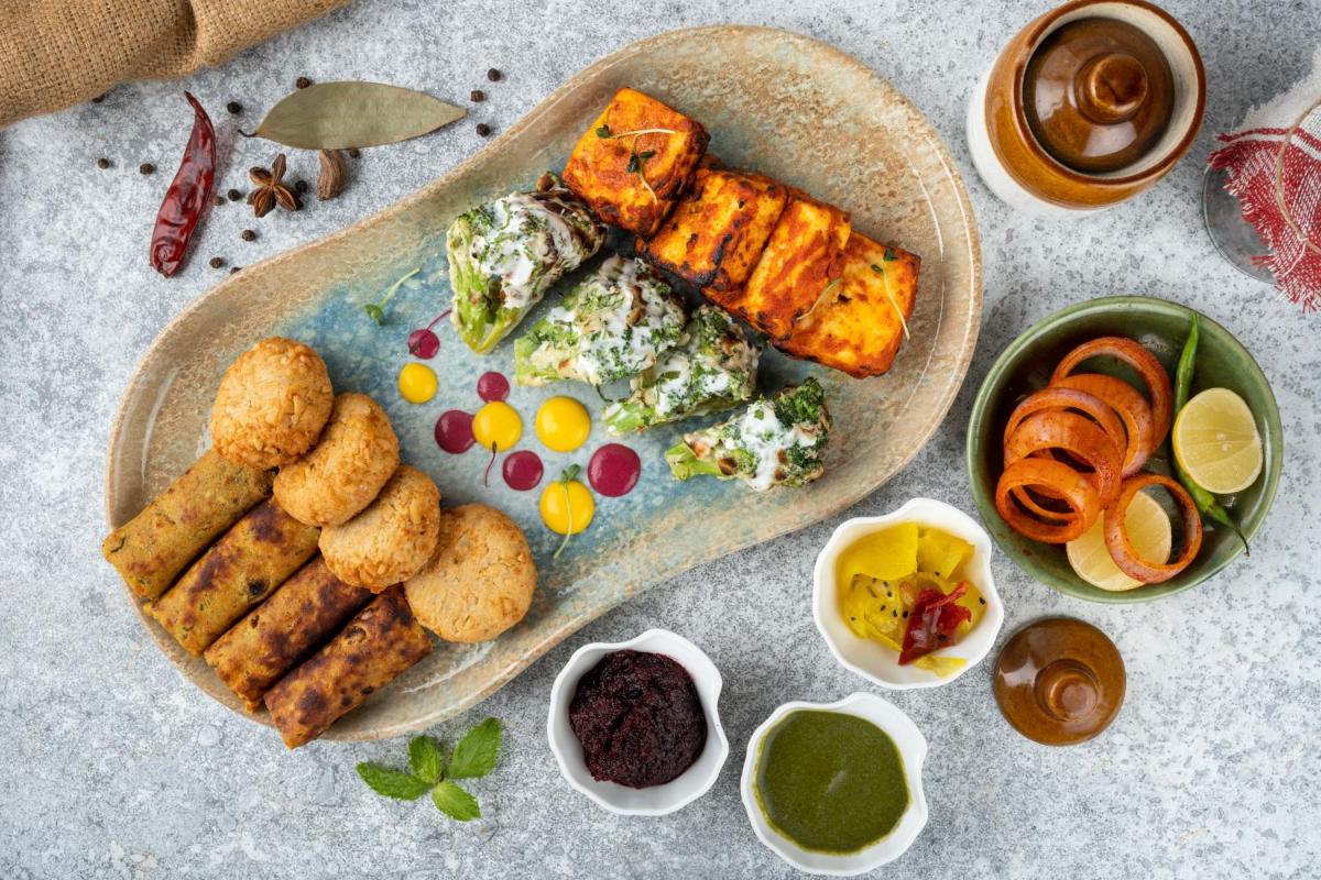 a plate of food on a table with food at Holiday Inn New Delhi Aerocity by IHG in New Delhi