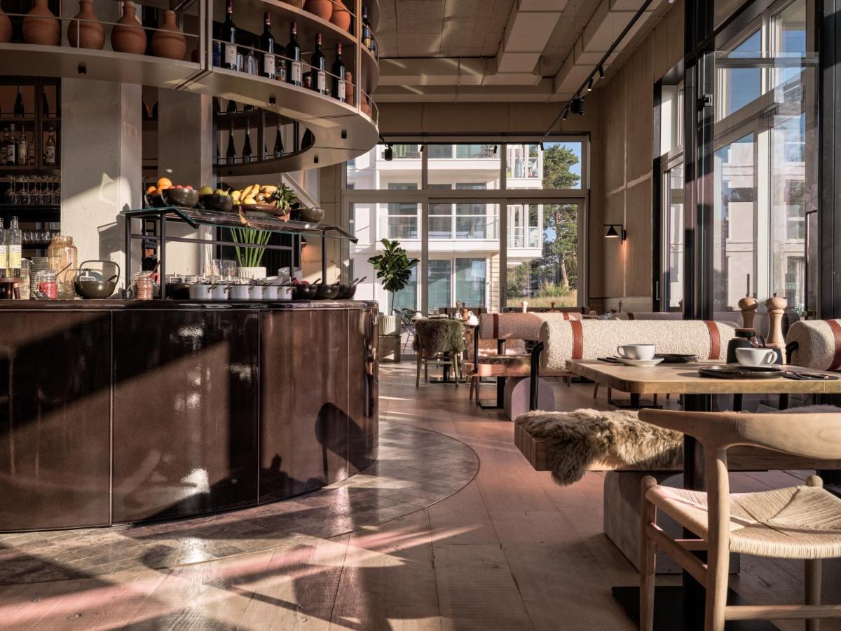 ein Restaurant mit einer Theke, Tischen und Fenstern in der Unterkunft the breeze in Ahlbeck