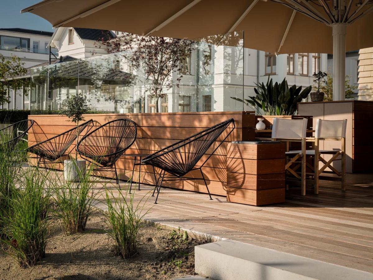 eine Terrasse mit Stühlen und einem Tisch mit einem Sonnenschirm in der Unterkunft the breeze in Ahlbeck