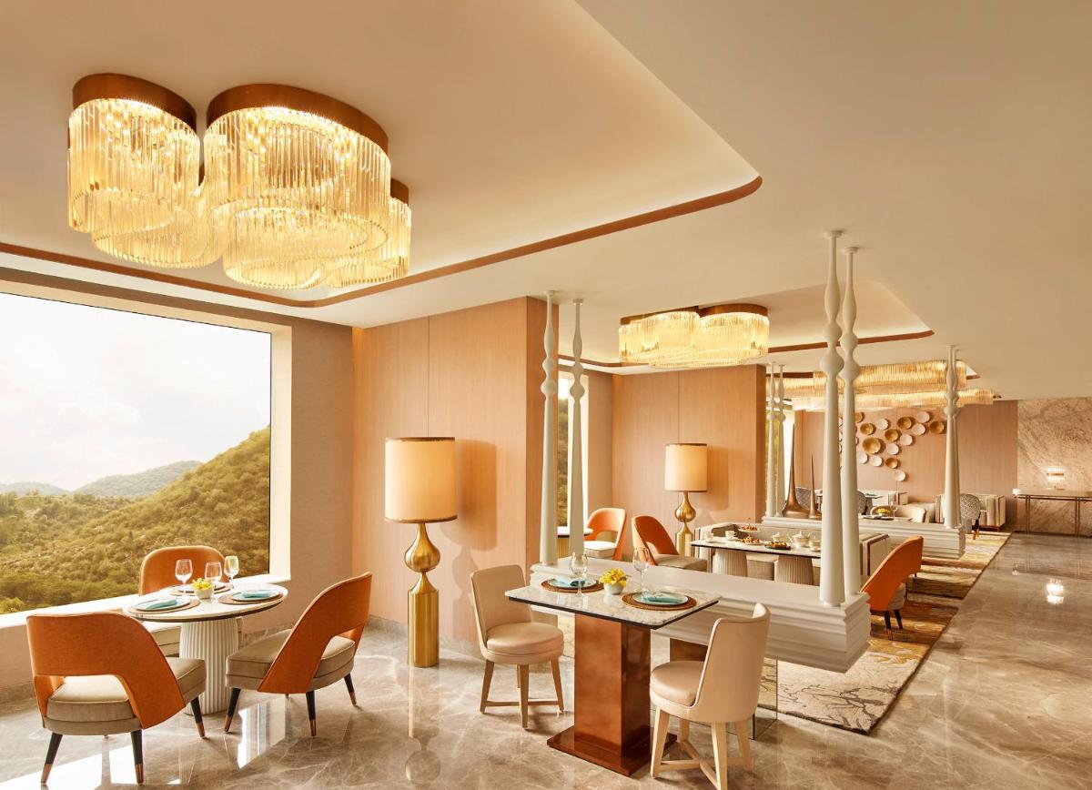 a room with tables and chairs and a large mirror at Taj Amer, Jaipur in Jaipur