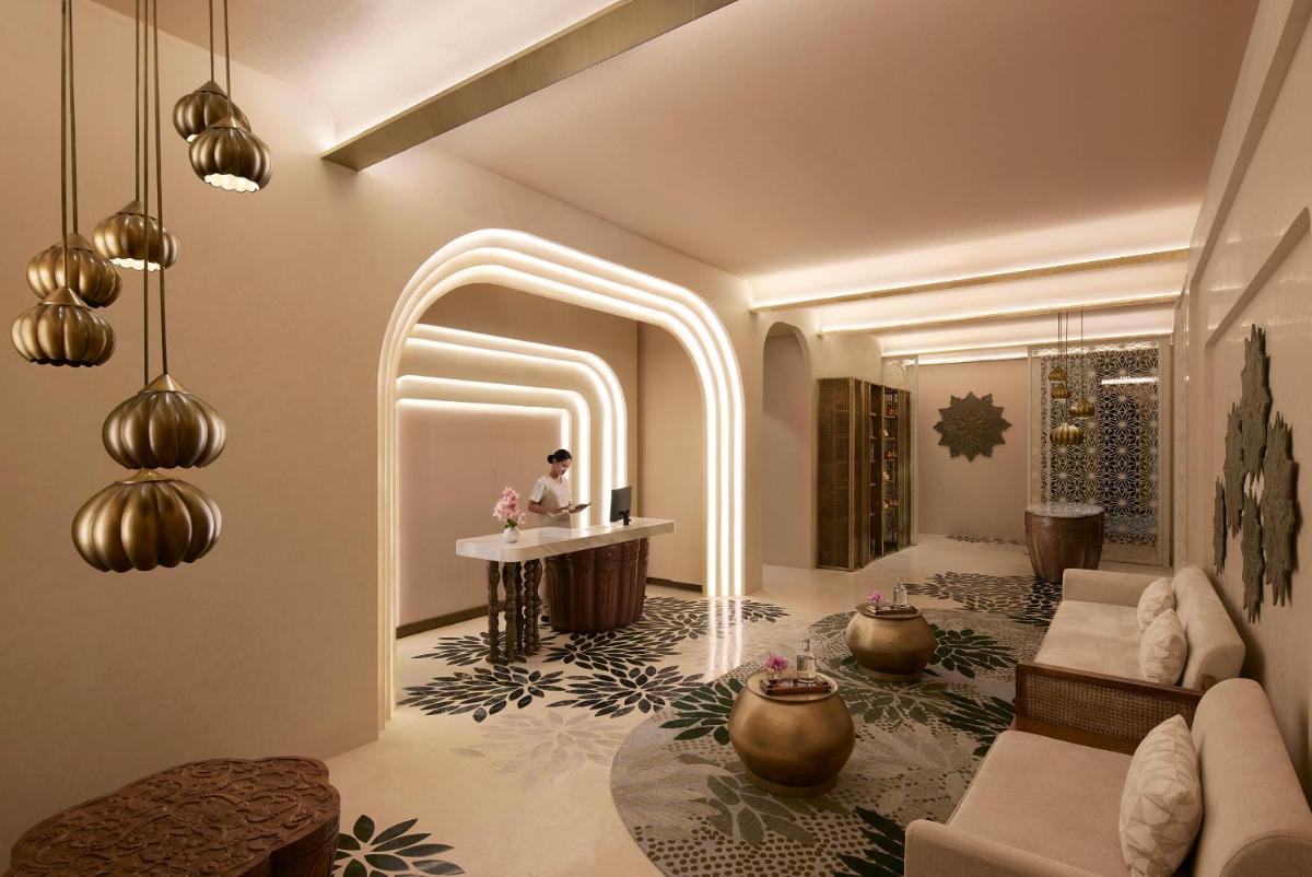 a living room with a woman sitting at a table in a room at Taj Amer, Jaipur in Jaipur