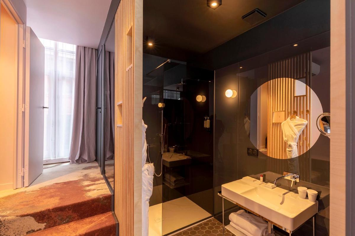 une salle de bain avec un lavabo et un miroir dans l'établissement Clarance Hotel Lille, à Lille 37 autres photos une salle de bain avec un lavabo et un miroir dans l'établissement Clarance Hotel Lille, à Lille 37 autres photos