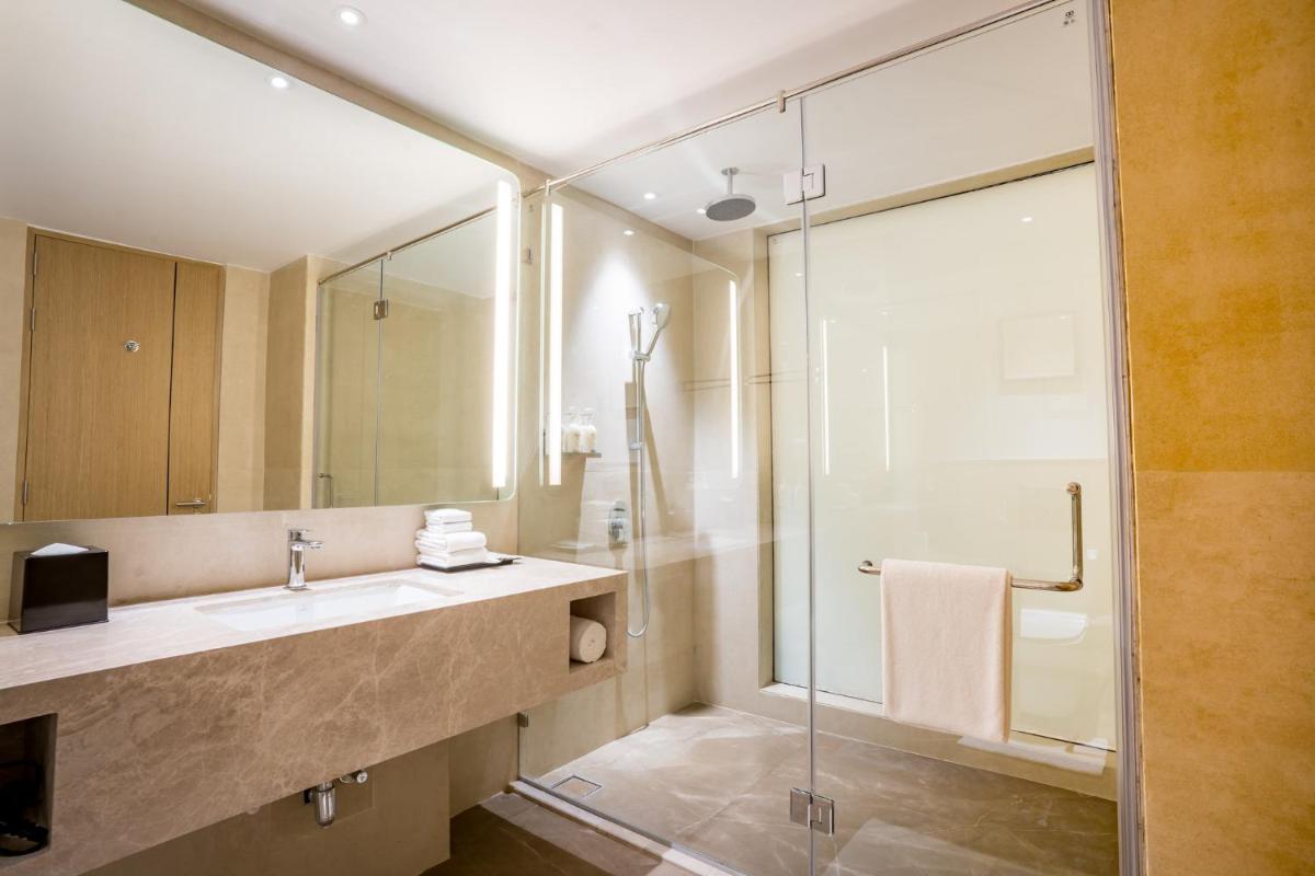 a bathroom with a sink and a glass shower at Holiday Inn Lucknow Airport by IHG in Lucknow