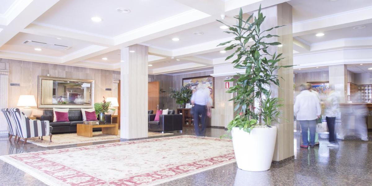 un vestíbulo con una gran planta en una olla blanca en Nuevo Astur Spa, en Sanxenxo