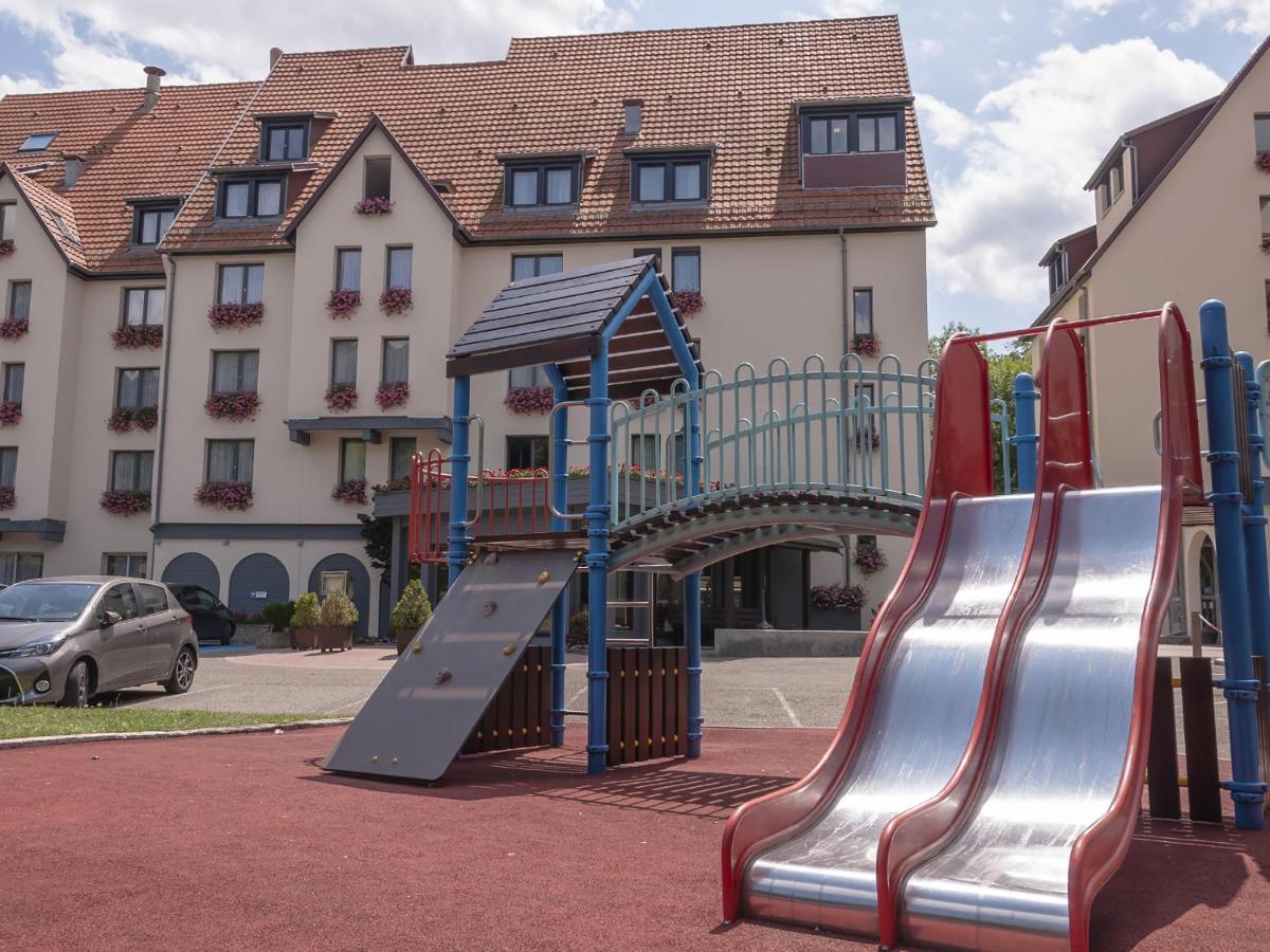 une aire de jeux devant un bâtiment avec un toboggan dans l'établissement Hotel Restaurant & Spa Verte Vallée, à Munster
