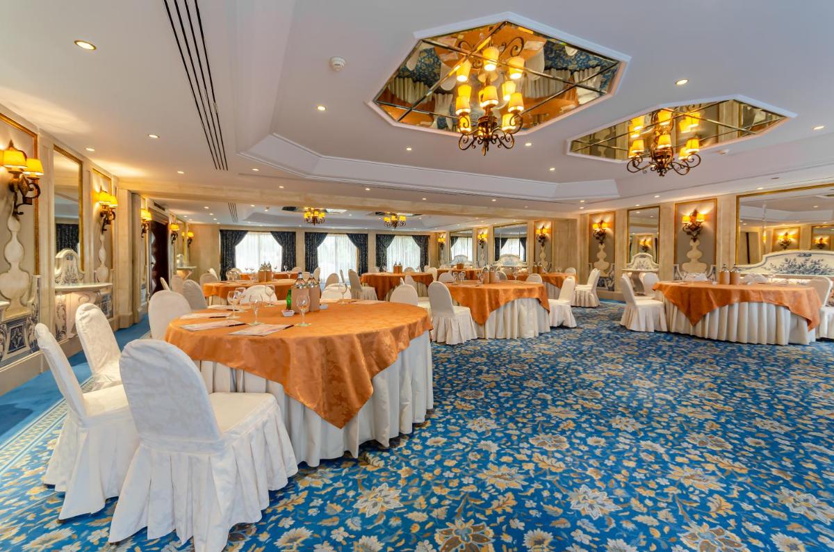 um salão de banquetes com mesas e cadeiras brancas em Olissippo Lapa Palace – The Leading Hotels of the World em Lisboa mais 110 fotografias