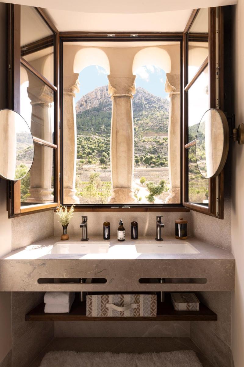 Un baño con una gran ventana y un lavabo. en Son Bunyola Resort and Villas, en Banyalbufar
