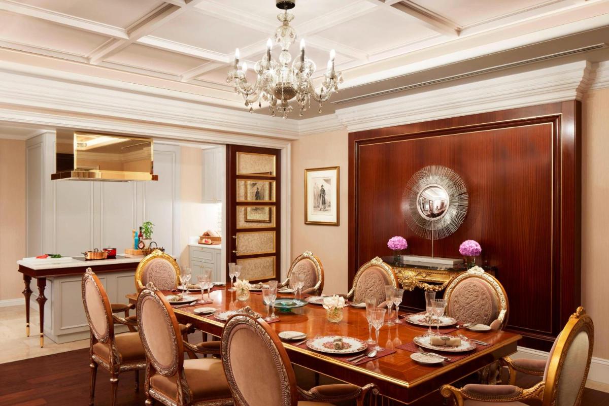 a dining room with a table and chairs and a chandelier at The Ritz-Carlton, Pune in Pune
