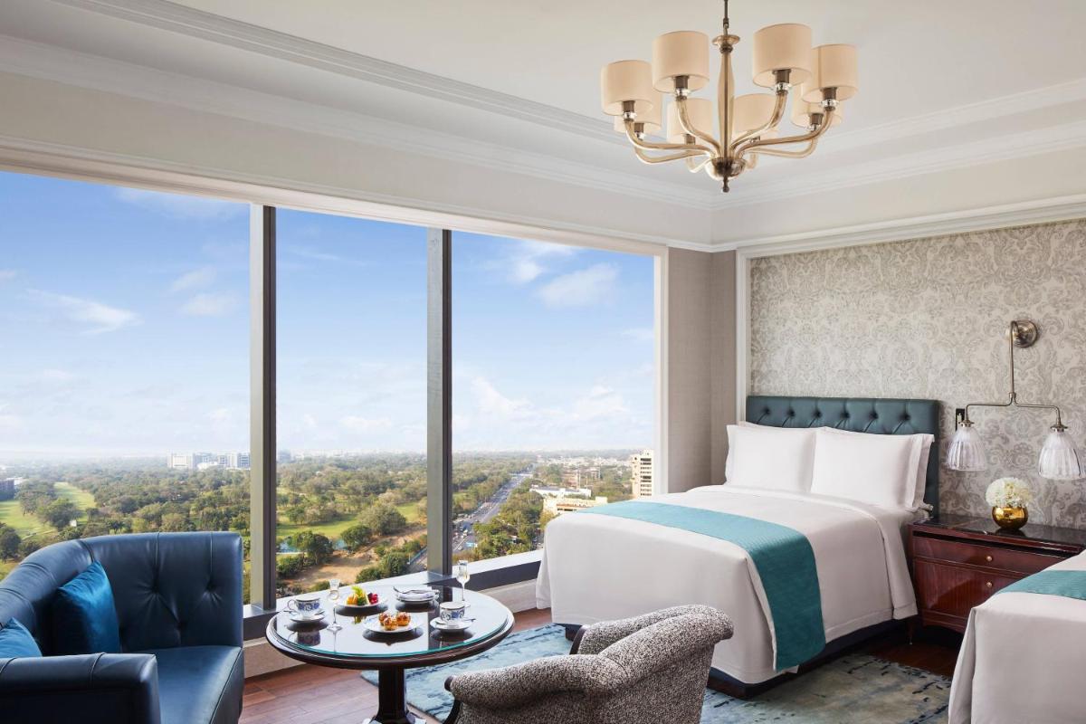a bedroom with a bed and a large window at The Ritz-Carlton, Pune in Pune