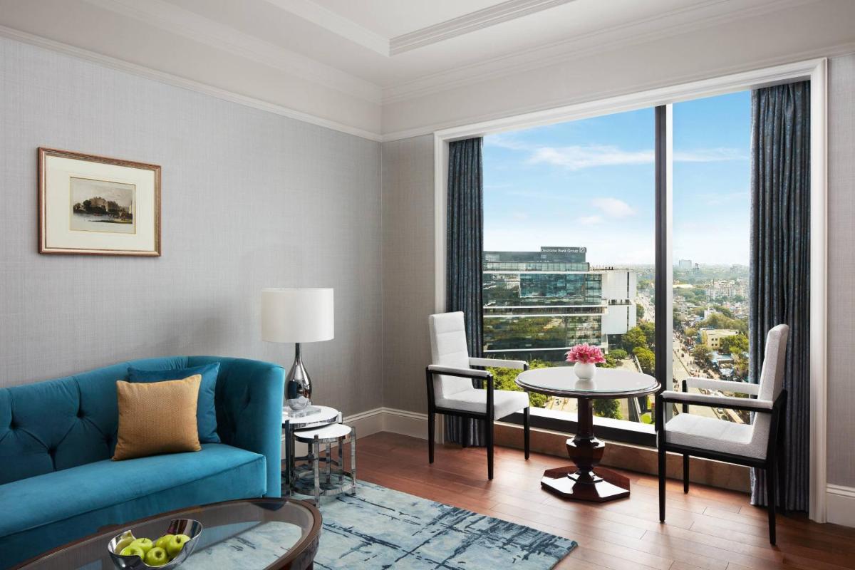 a living room with a blue couch and a table at The Ritz-Carlton, Pune in Pune