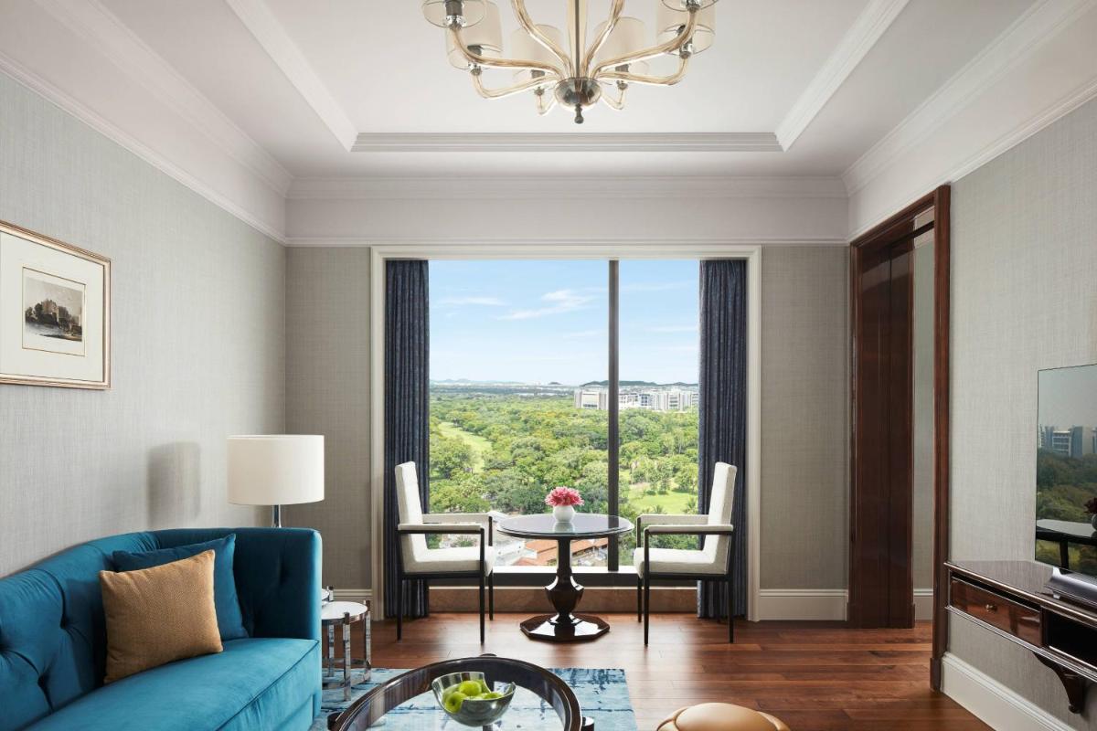 a living room with a blue couch and a table at The Ritz-Carlton, Pune in Pune +66 photos