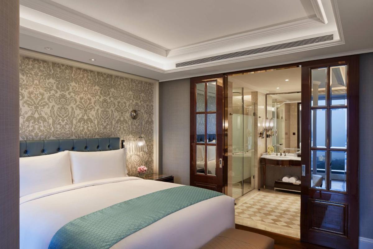a bedroom with a large bed and a bathroom at The Ritz-Carlton, Pune in Pune