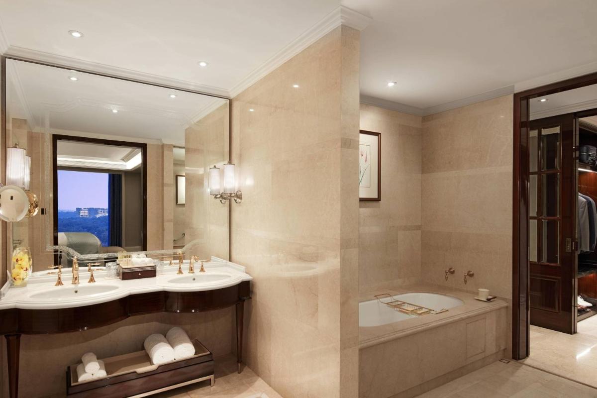 a bathroom with a sink and a tub and a mirror at The Ritz-Carlton, Pune in Pune