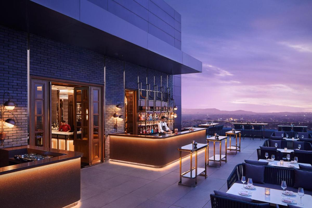 a restaurant with a bar with a view at The Ritz-Carlton, Pune in Pune