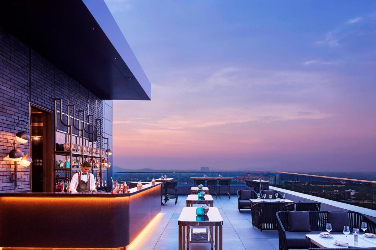 a restaurant with a bar on the roof of a building at The Ritz-Carlton, Pune in Pune