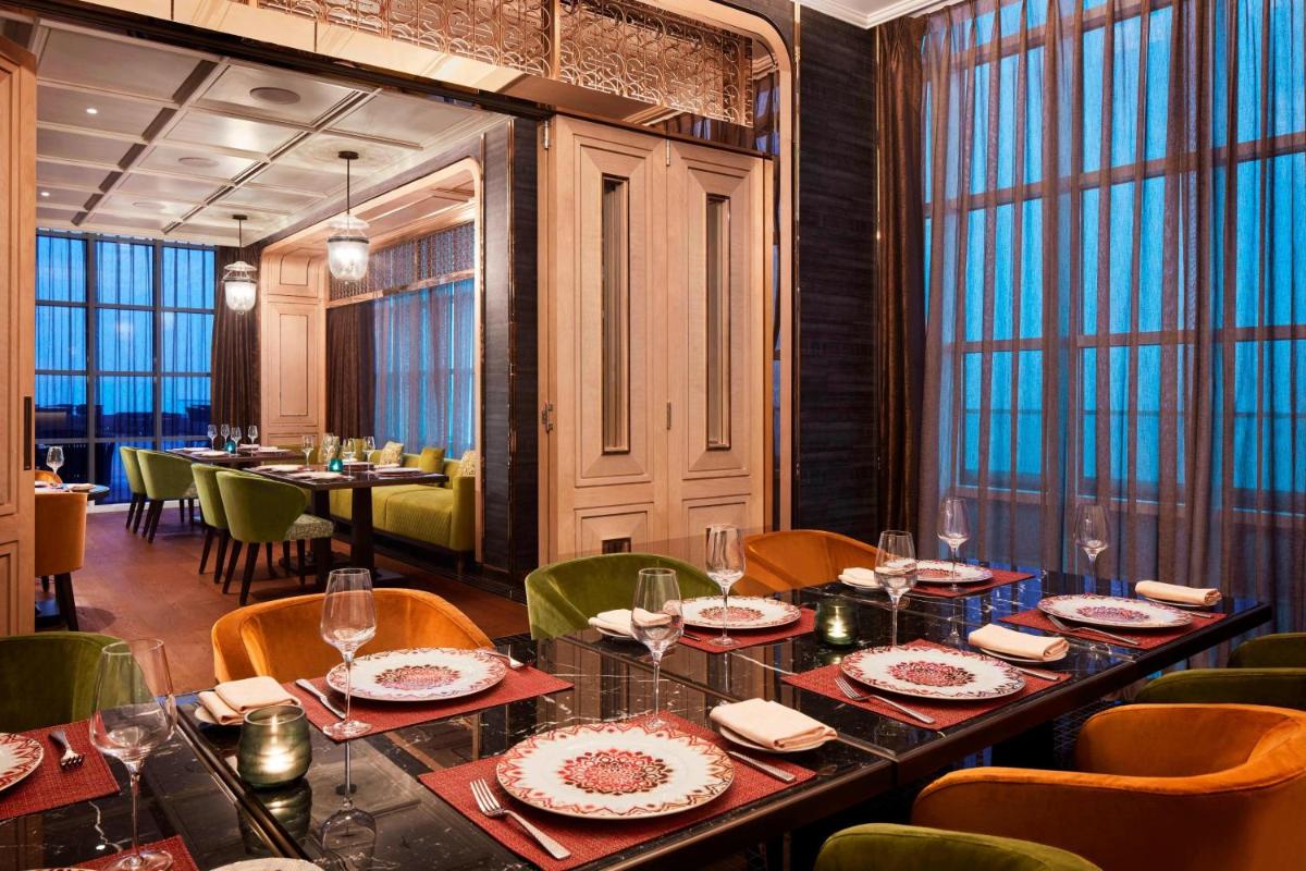 a dining room with a long table and chairs at The Ritz-Carlton, Pune in Pune