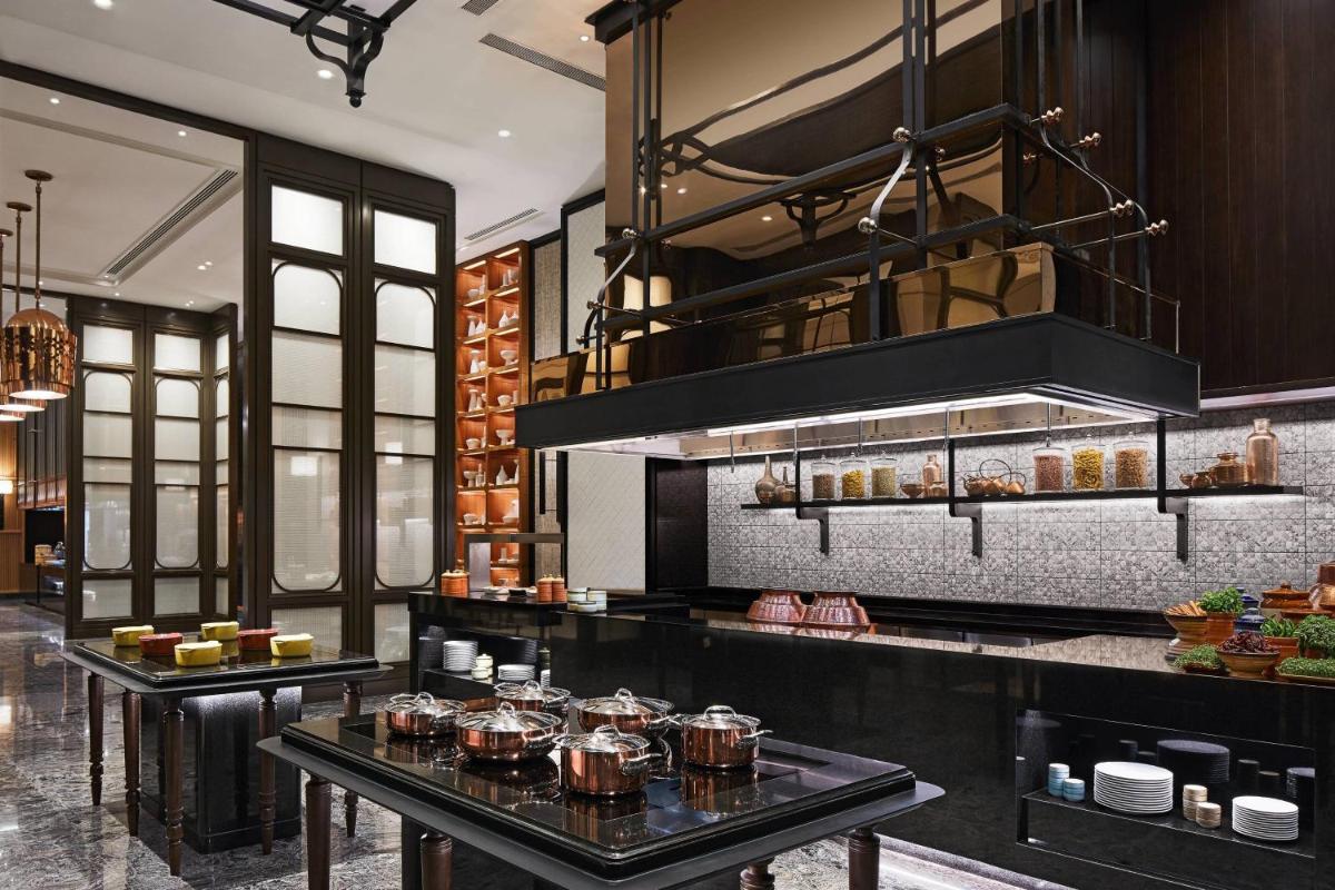 a kitchen with two tables with pots and pans at The Ritz-Carlton, Pune in Pune