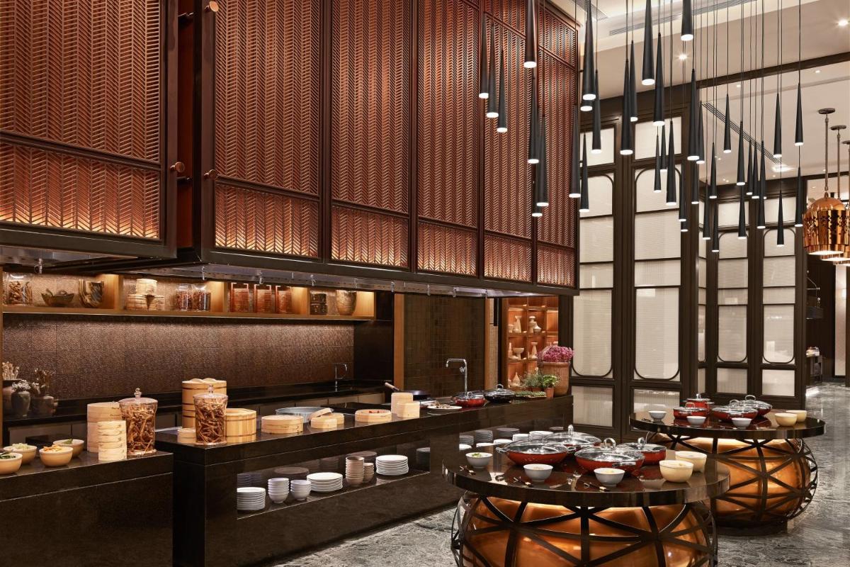 a restaurant with a buffet of food on display at The Ritz-Carlton, Pune in Pune