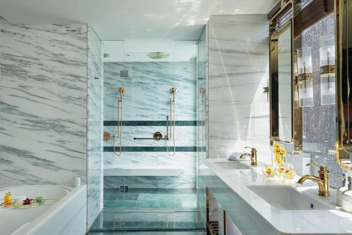 a bathroom with two sinks and a tub and a shower at The Ritz-Carlton, Pune in Pune
