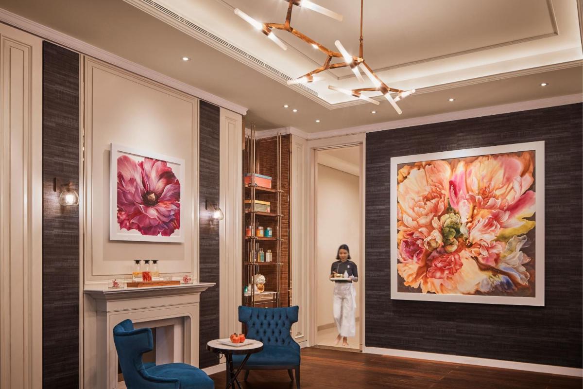 a woman standing in a lobby with a painting on the wall at The Ritz-Carlton, Pune in Pune