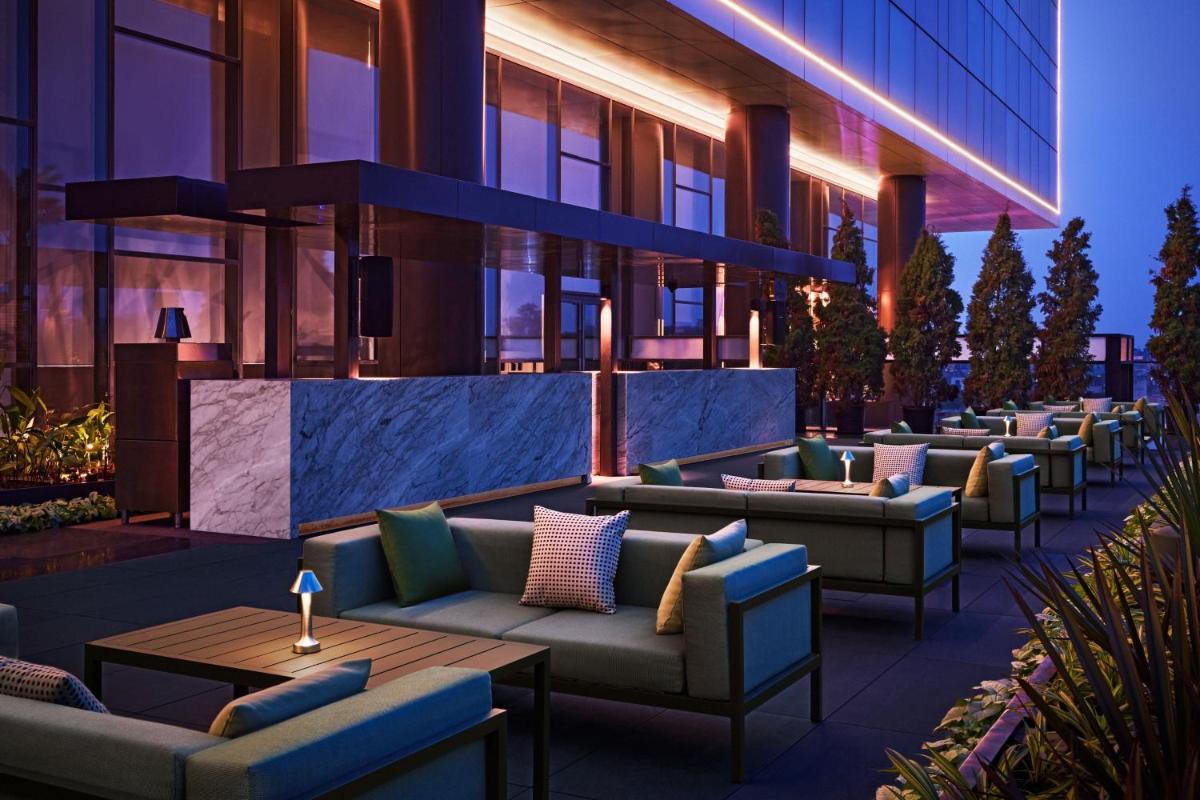 a bar with couches and tables in front of a building at The Ritz-Carlton, Pune in Pune