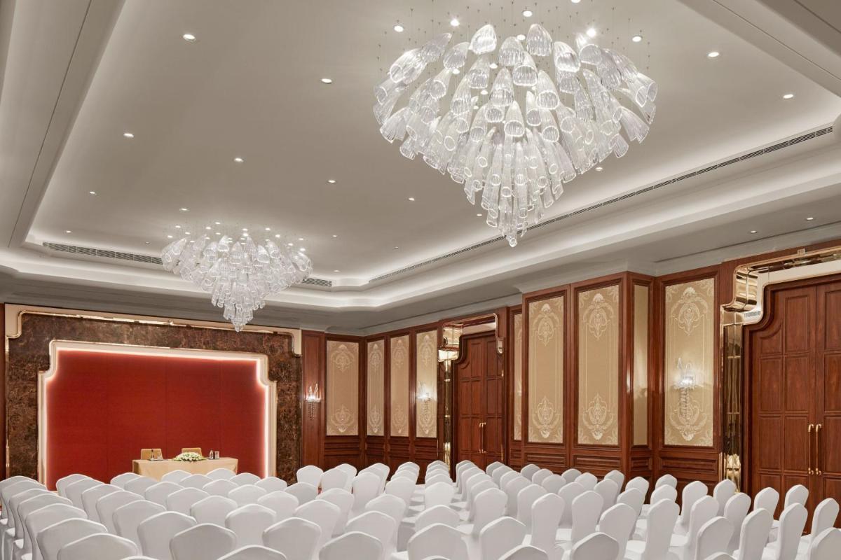 a conference room with white chairs and chandeliers at The Ritz-Carlton, Pune in Pune