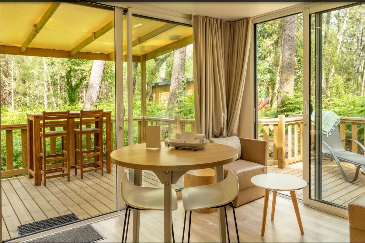 une véranda avec une table et des chaises dans l'établissement Green Resort, à Ondres