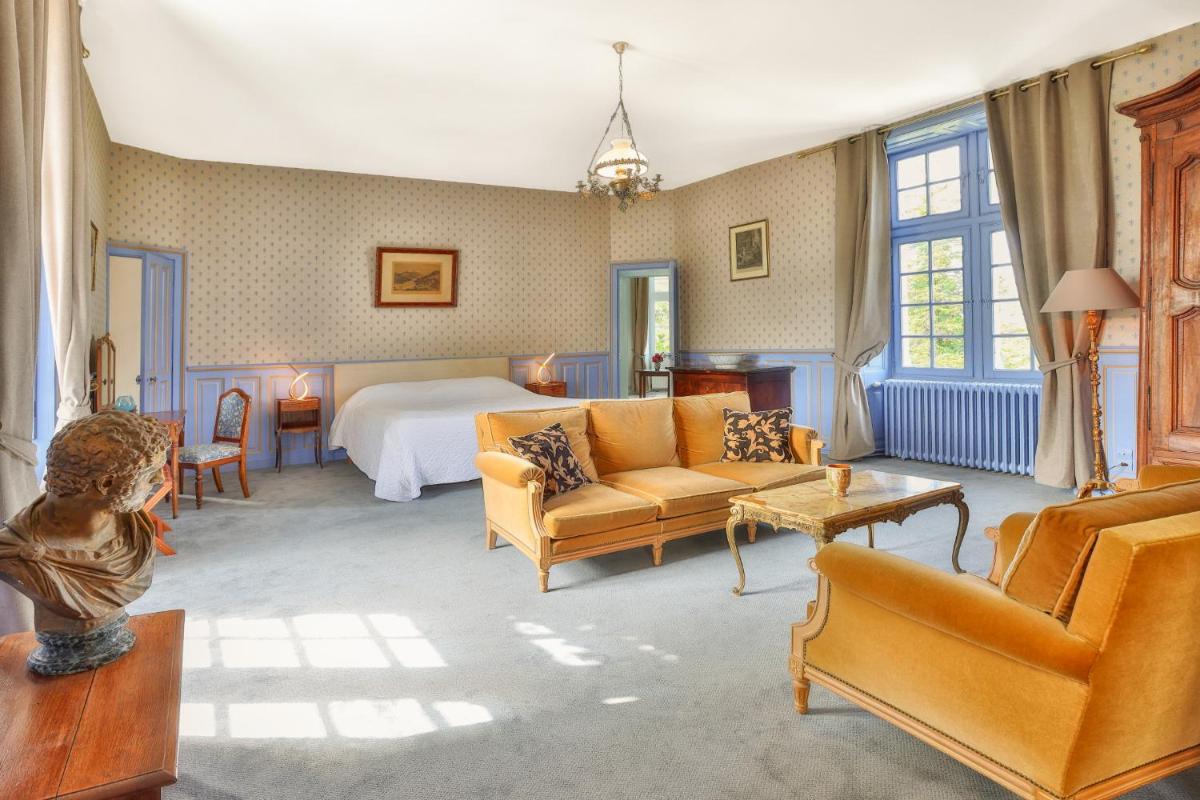 une chambre avec un lit, un canapé et des chaises dans l'établissement Hôtel & SPA Château de La Côte - Brantôme, à Biras