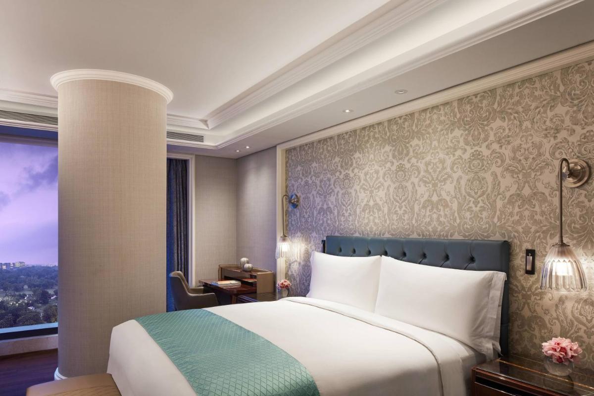 a hotel room with a bed and a window at The Ritz-Carlton, Pune in Pune