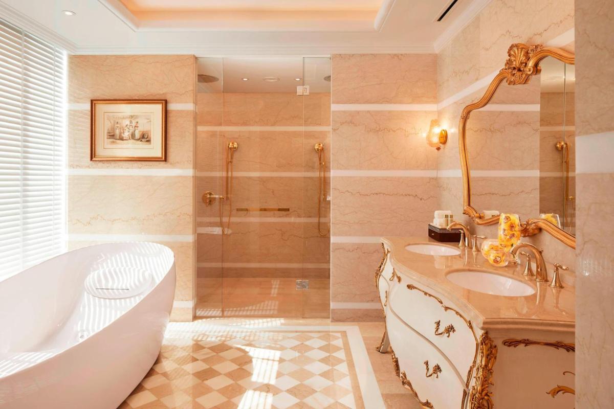 a bathroom with a tub and a sink and a bath tub at The Ritz-Carlton, Pune in Pune