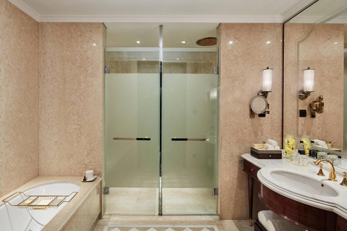 a bathroom with a shower and a tub and a sink at The Ritz-Carlton, Pune in Pune