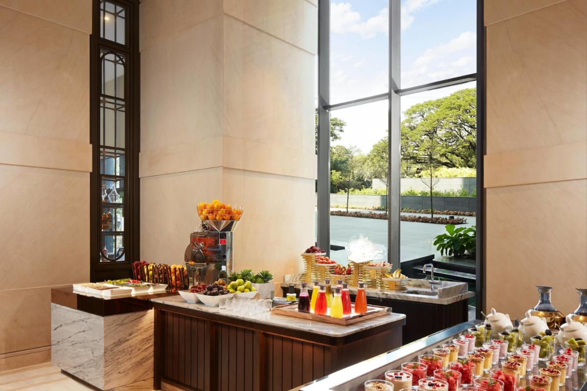 a buffet of food in a hotel lobby with a large window at The Ritz-Carlton, Pune in Pune