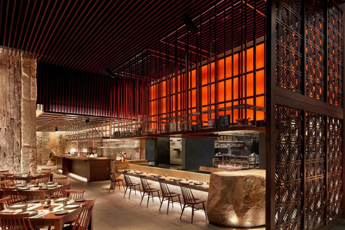 a restaurant with tables and chairs and a bar at The Ritz-Carlton, Pune in Pune