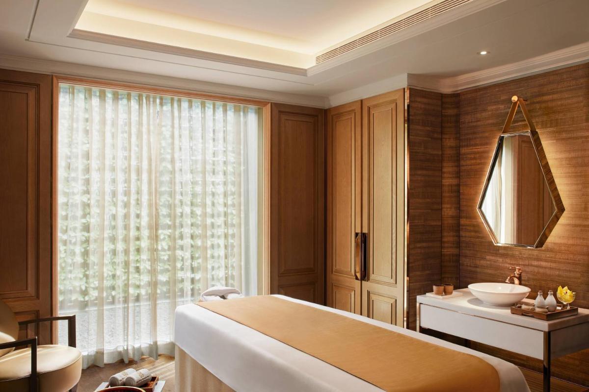 a bathroom with a large bed and a sink at The Ritz-Carlton, Pune in Pune