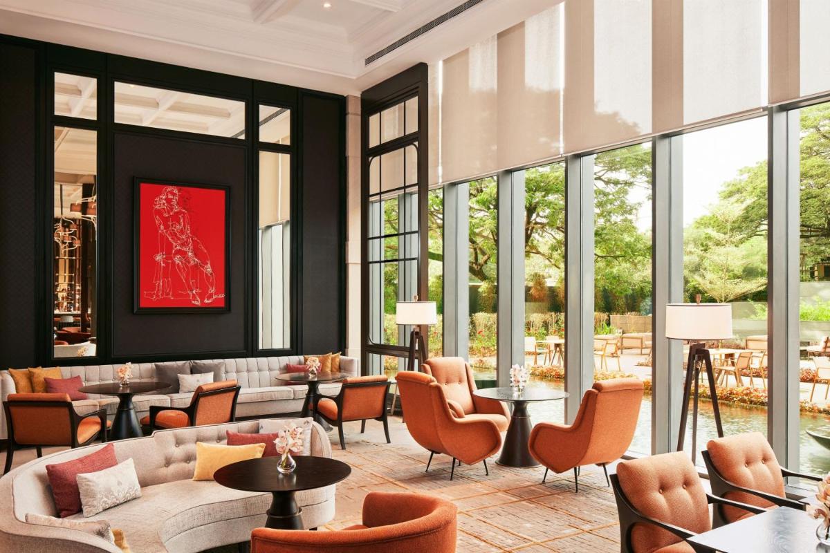 a lobby with couches and chairs and tables and windows at The Ritz-Carlton, Pune in Pune